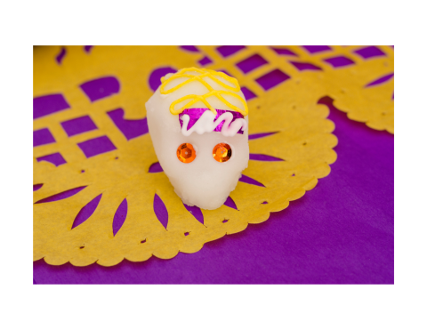 Small sugar skull placed on a tissue paper banner